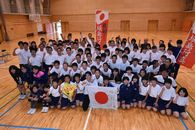 寄せ書きした日の丸をもった堀島選手と生徒たち