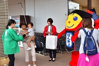 選挙啓発グッズを受け取る買い物客
