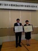写真：表彰状を持つ吉野ジーピーファームの代表者