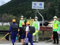 写真：児童とあいさつを交わしながら横断歩道を渡る様子を見守る田中市長