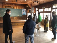 写真：ノスタルジックな雰囲気漂う旧校舎の案内を受ける田中市長