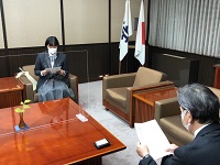 写真：受賞したエッセイを市長に紹介する三井さん