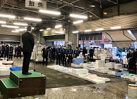 写真：初市の商品と市場関係者を前にあいさつする田中市長