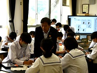 写真：活発にグループ討議をする生徒らの声を聴く田中市長
