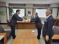 写真：市長に答申書を手渡す川上会長長と山下副会長