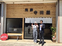 写真：木目調の店構えの飛騨寺田屋の前で寺田真由美社長と