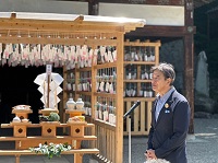写真：櫻山八幡宮の絵馬殿に取り付けられた風鈴の前であいさつする田中市長