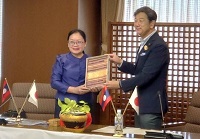 写真：シリポン・スパントーン副知事から伝統工芸品の織物を贈られる田中市長