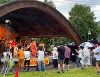 写真：清見町ウッドフォーラム飛騨の野外ステージでのライブを芝生の上で楽しむ観客