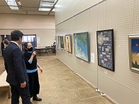 写真：説明を聞きながら絵画作品を鑑賞する田中市長