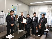 写真：長谷川官房審議官に提言書を手渡す沿線自治体の首長