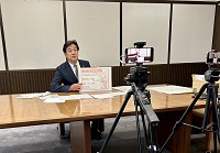 写真：カメラに向かって子育て支援策について紹介する田中市長