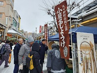 写真：メイド・バイ飛騨高山認証品の「小屋名（こやな）しょうけ」の出店者と話す田中市長