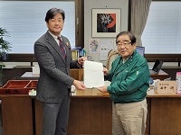 写真：北村会長から意見書を受領する田中市長