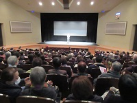 写真：会場いっぱいの来場者を前に開会のあいさつをする田中市長