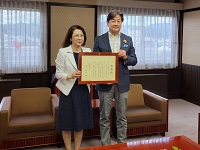 市感謝状の贈呈を受けた益田祐美子平成プロジェクト代表取締役社長と市長