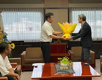 下田雅人くぐの夏のイベント協議会会長からひまわりの花束を受け取る市長