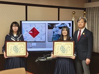 受賞した斐太高校の小阪莉央さん、田尻侑さんと作品をバックに記念撮影