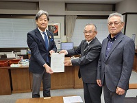 川上実市国民健康保険運営協議会会長らから答申書を受領する市長