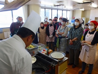 参加者の前で料理の実演をする佐藤総料理長