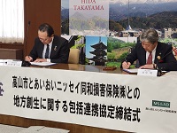 あいおいニッセイ同和損害保険との包括連携協定締結にサインをする市長