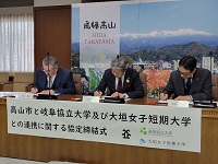 市との連携に関する協定締結にサインする学長ら