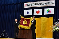 市立荘川さくら学園の校旗を掲げる市長と校長先生