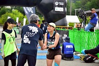 ウルトラマラソンを完走したランナーと握手をし労いの言葉をかける市長