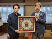 書画家伊藤一樹さんからさるぼぼの書画作品を受贈する市長