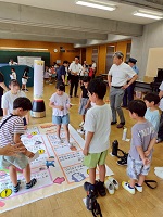 「もしもに備えて防災を楽しく学ぶ”防災縁日”」の防災すごろくを見学する市長