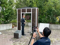 「平和への絆」の前で市公式YouTubeの収録を行う市長